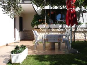 un tavolo bianco e sedie su un patio di Apartman Klimic a Umag (Umago)