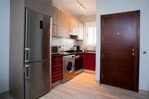 a kitchen with a stainless steel refrigerator and red cabinets at Apartamento Vadim in Ardales