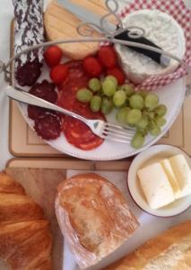 a plate of food with grapes and cheese and bread at Chambre d'Hôtes Oiron, Deux Sevres - not near Taize, Burgundy in Oiron