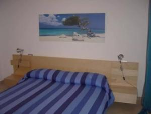 1 cama en un dormitorio con una foto en la pared en Residence Horisontis, en Pineto