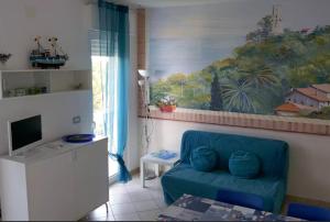 una sala de estar con un sofá azul y una pintura en Residence Horisontis, en Pineto