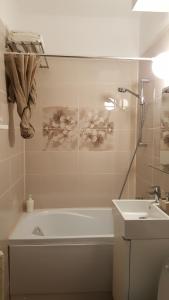 un bagno con vasca e lavandino di Iri's Downtown Apartment no. 1 a Ploieşti