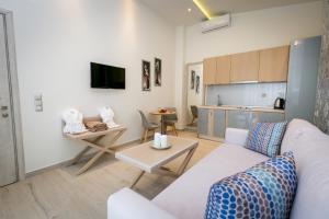 a living room with a white couch and a table at Lobelia Luxury Suites in Chrysi Ammoudia