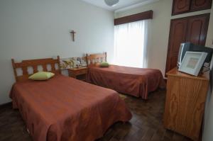 a hotel room with two beds and a television at Apartamentos Turisticos Ceu Azul in Arcozelo