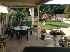 eine Terrasse mit einem Tisch und Stühlen sowie einem Garten in der Unterkunft Les charmes in Valençay