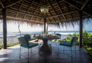 a patio with a table and chairs and the ocean at Satin Doll in Unawatuna