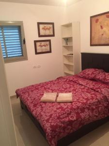 a bedroom with a red bed with two towels on it at Tuscany get-away apartment in Daverat