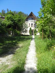 uma estrada de terra que leva a uma grande casa branca em Zviad Guest House em Borjomi
