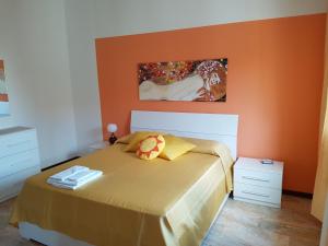a bedroom with a bed with an orange wall at B&B Soleluna in Massa Fiscaglia