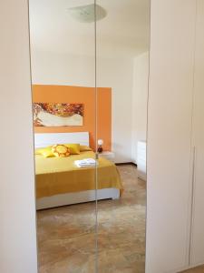 a bedroom with a yellow bed and a glass wall at B&B Soleluna in Massa Fiscaglia