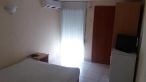 a bedroom with a bed and a television and a window at Apartments Villa Dadora in Sutomore