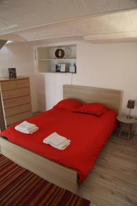 カンヌにあるFlat Palais Cannesのベッドルーム1室(赤いベッド1台、タオル2枚付)