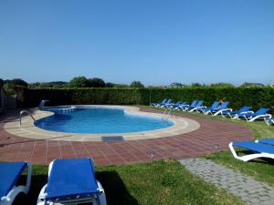 einen Pool mit Liegestühlen und eine Gruppe in der Unterkunft Hotel Brisa da Lanzada in A Lanzada