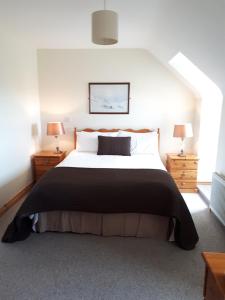 a bedroom with a large bed and two night stands at The Creggs in Ballyvaughan