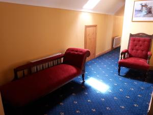 a room with two chairs and a red couch at The Creggs in Ballyvaughan