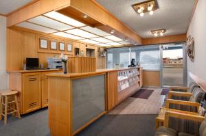 a kitchen with wooden cabinets and a large window at SkyView Swift Current in Swift Current