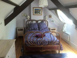 1 dormitorio con cama de metal y almohadas moradas en Gîte du Vert Rivage à Stang Korvenn, en Laz