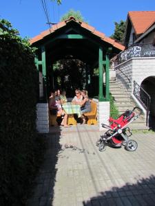 grupa ludzi siedzących przy stole ze skuterem w obiekcie Magda Vendégház w Tokaju