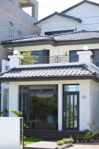 a white house with a large glass door at Begonia B&B in Taitung City