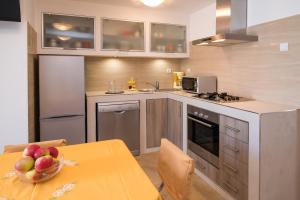 a kitchen with a table with a bowl of fruit at Apartment Andrija in Vrbnik +62 photos