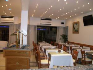 a dining room with white tables and chairs at Village Garden Apart Hotel in Buenos Aires