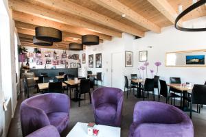 a restaurant with purple chairs and tables and a bar at Hotel Operà in Dossobuono