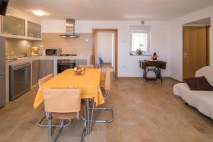 a kitchen and living room with a yellow table and chairs at Apartment Andrija in Vrbnik