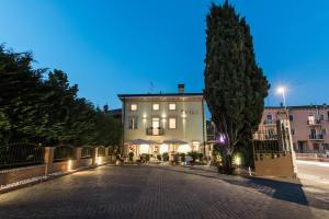 eine Kopfsteinpflasterstraße vor einem Gebäude in der Unterkunft Hotel Operà in Dossobuono