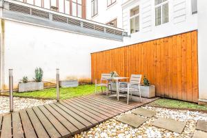 een patio met een tafel en stoelen naast een hek bij Beautiful apartment in Vienna's heart in Wenen