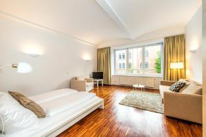 ウィーンにあるBeautiful apartment in Vienna's heartの白いベッドルーム(ベッド1台、ソファ付)