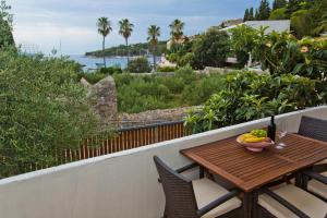 a wooden table with a bowl of fruit on a balcony at Apartments Grgo in Hvar