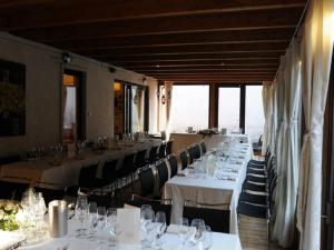 a dining room with tables and chairs with white tablecloths at La Casa del Sogno in Monteforte dʼAlpone
