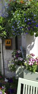 a white bench sitting next to a bunch of flowers at Birchleigh Guest House in Grange Over Sands