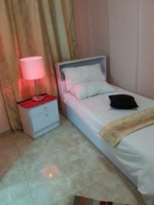 1 dormitorio con cama y mesita de noche con lámpara en My Home Petra en Wadi Musa