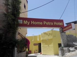 a sign for my home petita hotel in front of a building at My Home Petra in Wadi Musa