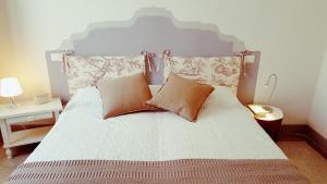 a bedroom with a large bed with two pillows at Montevenere 83 in Chiusi