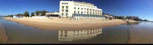 a building on the beach with its reflection in the water at Hotel Amyclae in Sperlonga