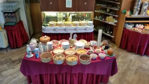 a table with bowls of food on a purple table at Hotel Villa Emilia in Ortisei