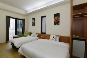 ein Hotelzimmer mit 2 Betten und einem Fenster in der Unterkunft Begonia B&B in Taitung