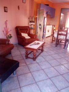 een woonkamer met een bank en een salontafel bij SA DOMU SARDA CASE VACANZe in Piscinas