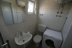 a bathroom with a toilet sink and a washing machine at Apartmani Popović Nin in Nin +43 photos