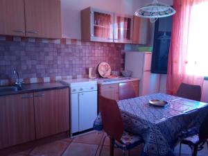 a kitchen with a table and a table and a sink at Sa Domu Sarda casa vacanza in Piscinas