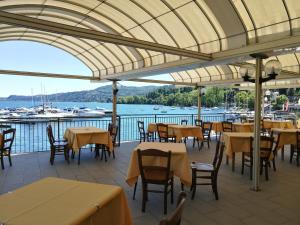 a restaurant with tables and chairs and a view of the water at Hotel Capri in Lesa