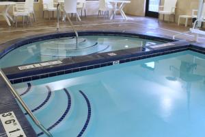 a swimming pool with blue water in a hotel room at Heartland Inn and Suites in Wheatland