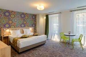 Un dormitorio con una cama y una mesa y sillas. en Blumenhaus Sibiu, en Sibiu