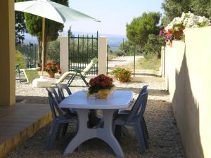 a blue table with chairs and an umbrella at Les Cigales du Ventoux in Le Barroux