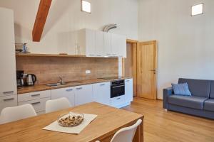een keuken met een tafel en een blauwe bank bij Aparthotel Kovarna Residence in Pec pod Sněžkou