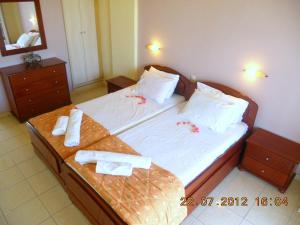 a bedroom with a large bed with towels on it at Canditas Studios in Tsilivi