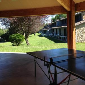 a black table on a patio with a yard at VVF Haute Loire Saint-Julien-Chapteuil in Saint-Julien-Chapteuil
