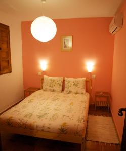 ein Schlafzimmer mit einem Bett mit orangefarbenen Wänden und 2 Lampen in der Unterkunft El Corrillo in Trevejo